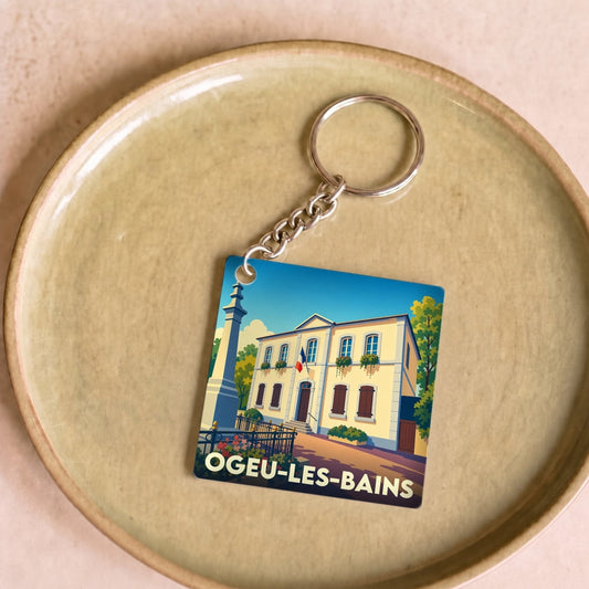 Porte-clés souvenir de la ville d'Ogeu-les-Bains avec une illustration stylisée.