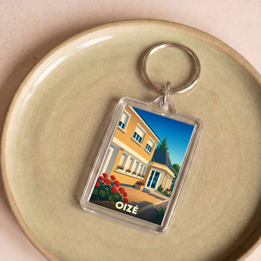 Porte-clés souvenir de la ville de Oizé avec une illustration stylisée d'une maison fleurie.