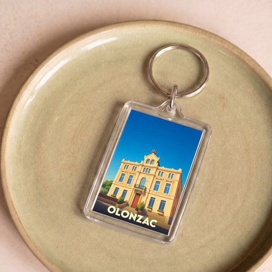 Porte-clés souvenir de la ville d'Olonzac avec une illustration stylisée de sa mairie.