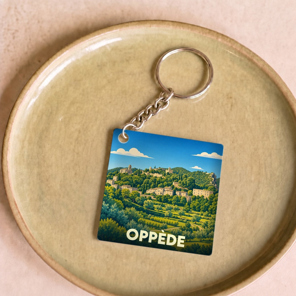 Porte-clés souvenir de la ville de Oppède avec une illustration stylisée du village provençal.