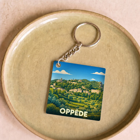 Porte-clés souvenir de la ville de Oppède avec une illustration stylisée du village provençal.