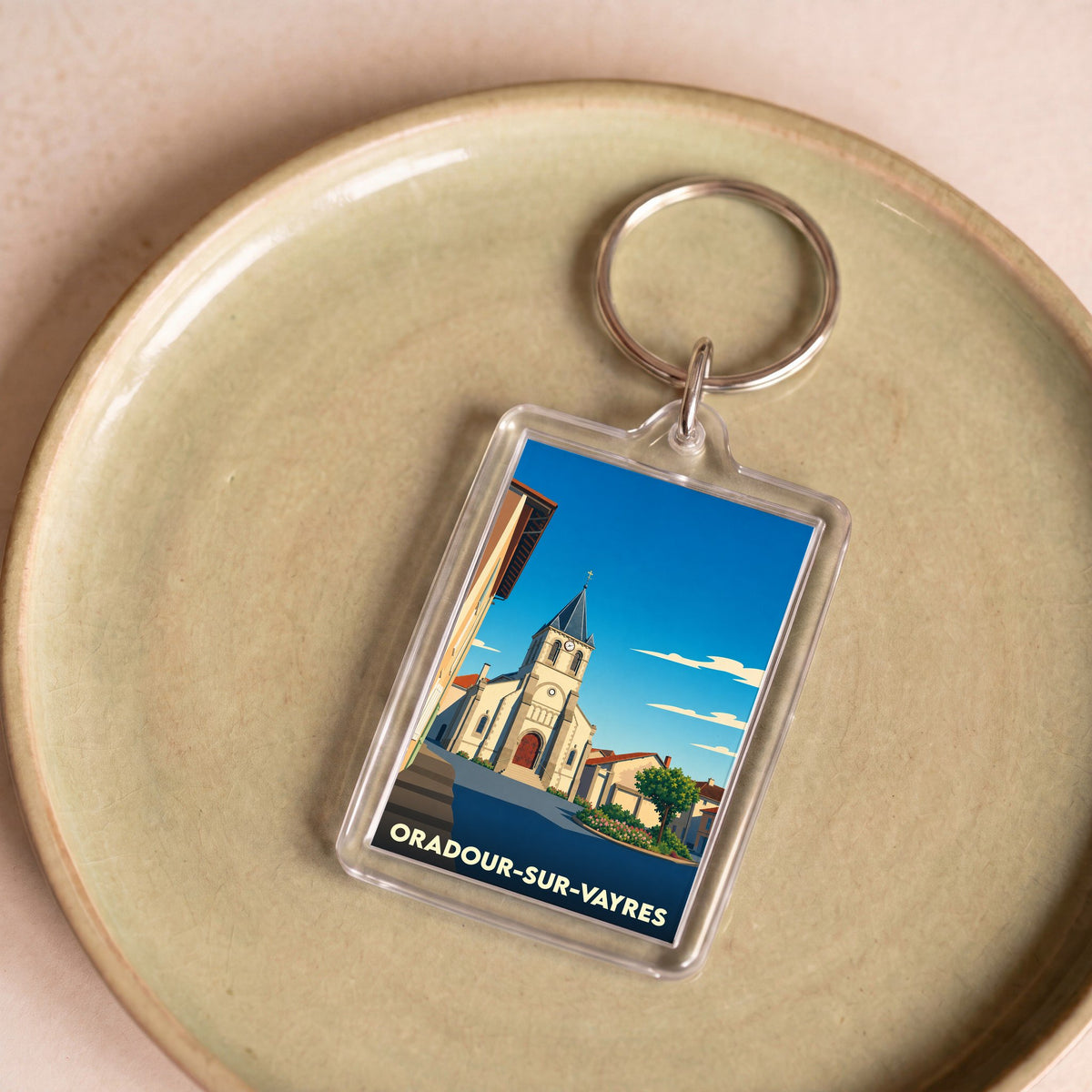 Porte-clés souvenir de la ville de Oradour-sur-Vayres avec une illustration stylisée de son église.
