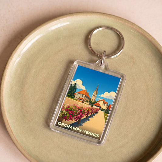 Porte-clés souvenir de la ville d'Orchamps-Vennes avec une illustration stylisée.