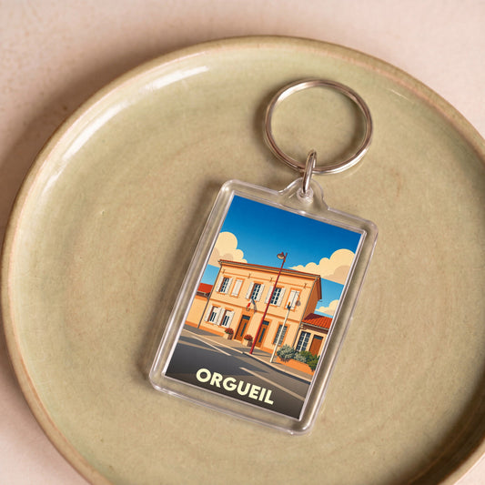 Porte-clés souvenir de la ville d'Orgueil avec une illustration stylisée.
