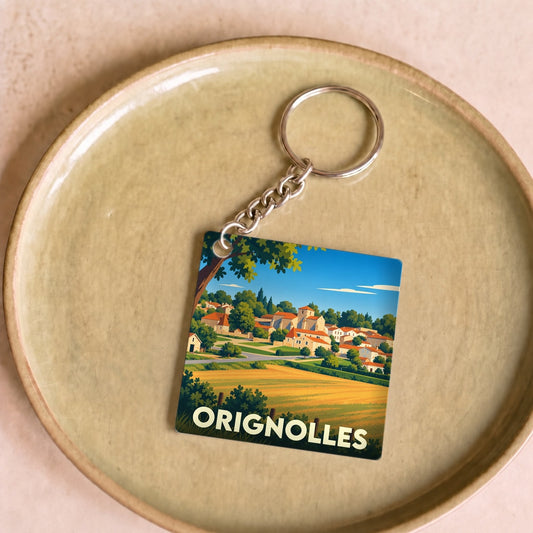 Porte-clés souvenir de la ville d'Orignolles avec une illustration stylisée d'un paysage de campagne.