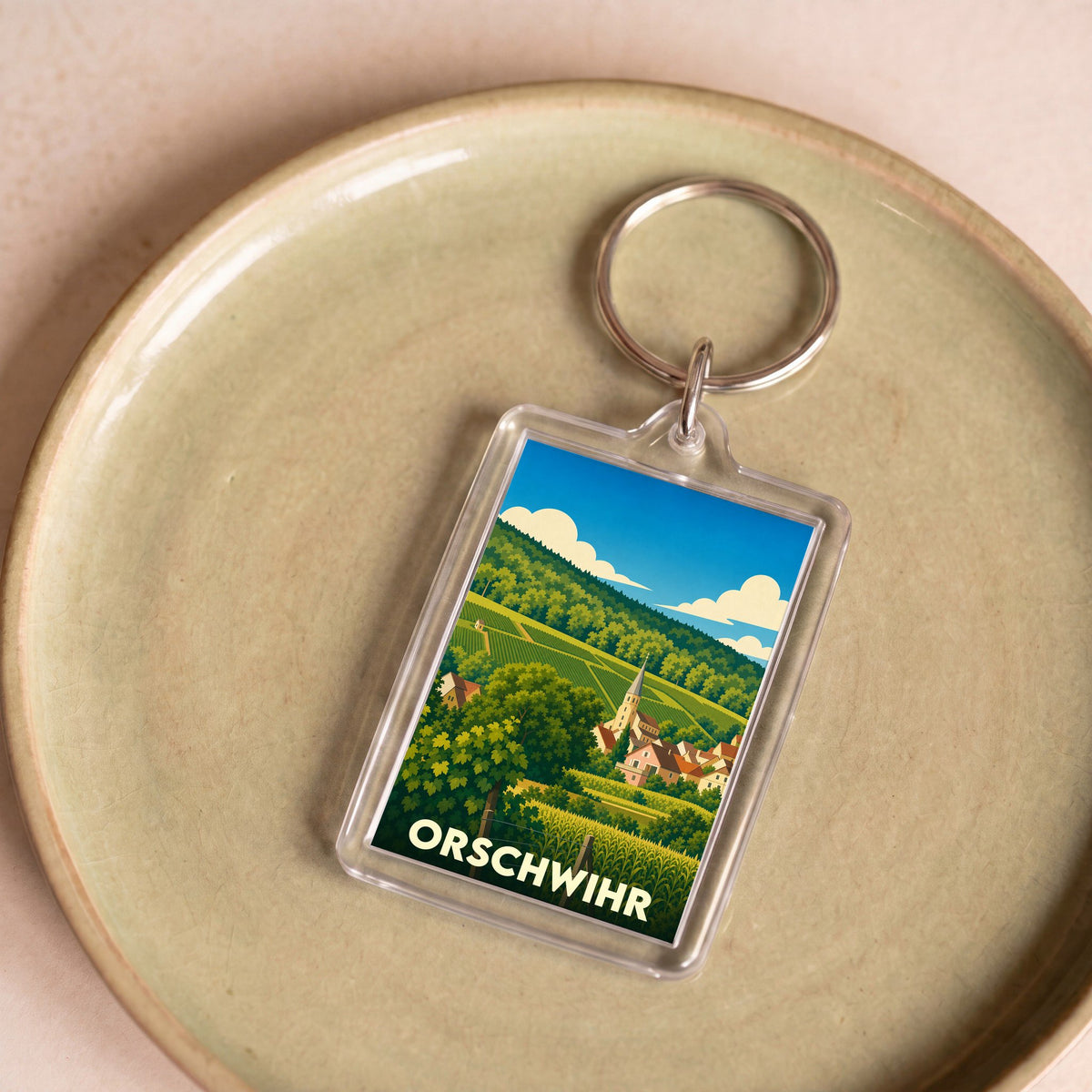 Porte-clés souvenir de la ville de Orschwihr avec une illustration stylisée de son paysage vallonné.