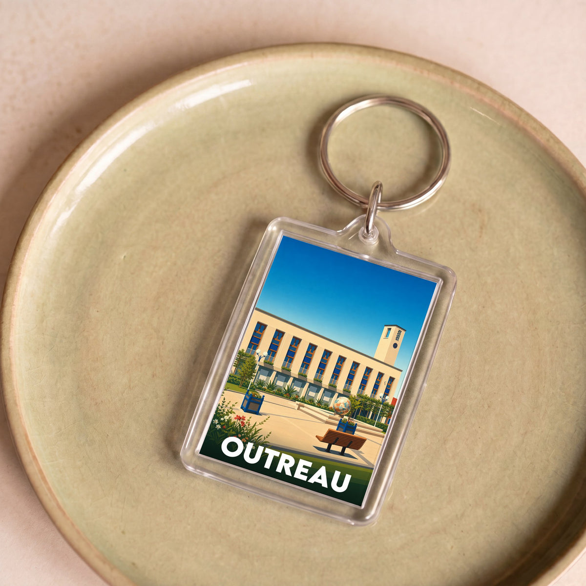 Porte-clés souvenir de la ville d'Outreau avec une illustration stylisée de son architecture.