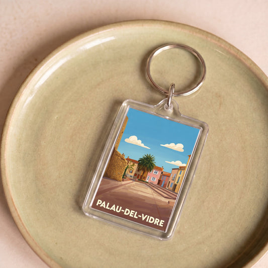 Porte-clés souvenir de la ville de Palau-del-Vidre avec une illustration stylisée.