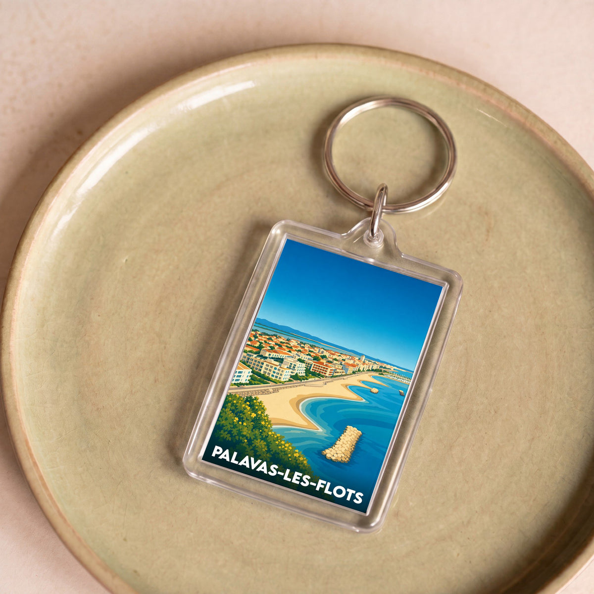 Porte-clés souvenir de la ville de Palavas-les-Flots avec une illustration stylisée de son bord de mer.