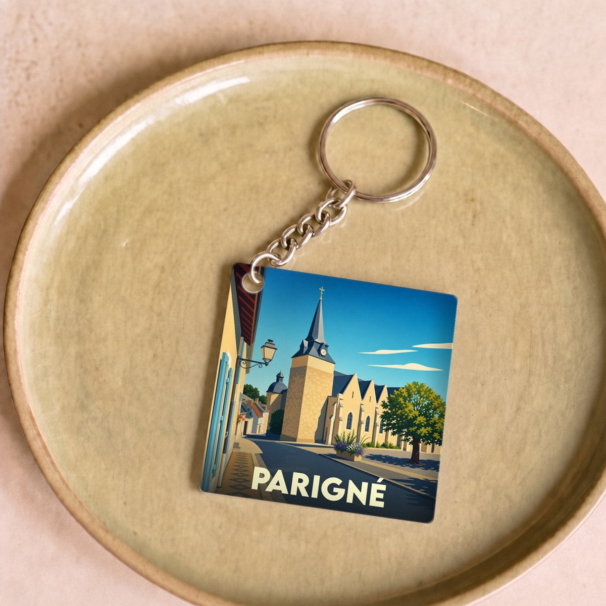 Porte-clés souvenir de la ville de Parigné avec une illustration stylisée.