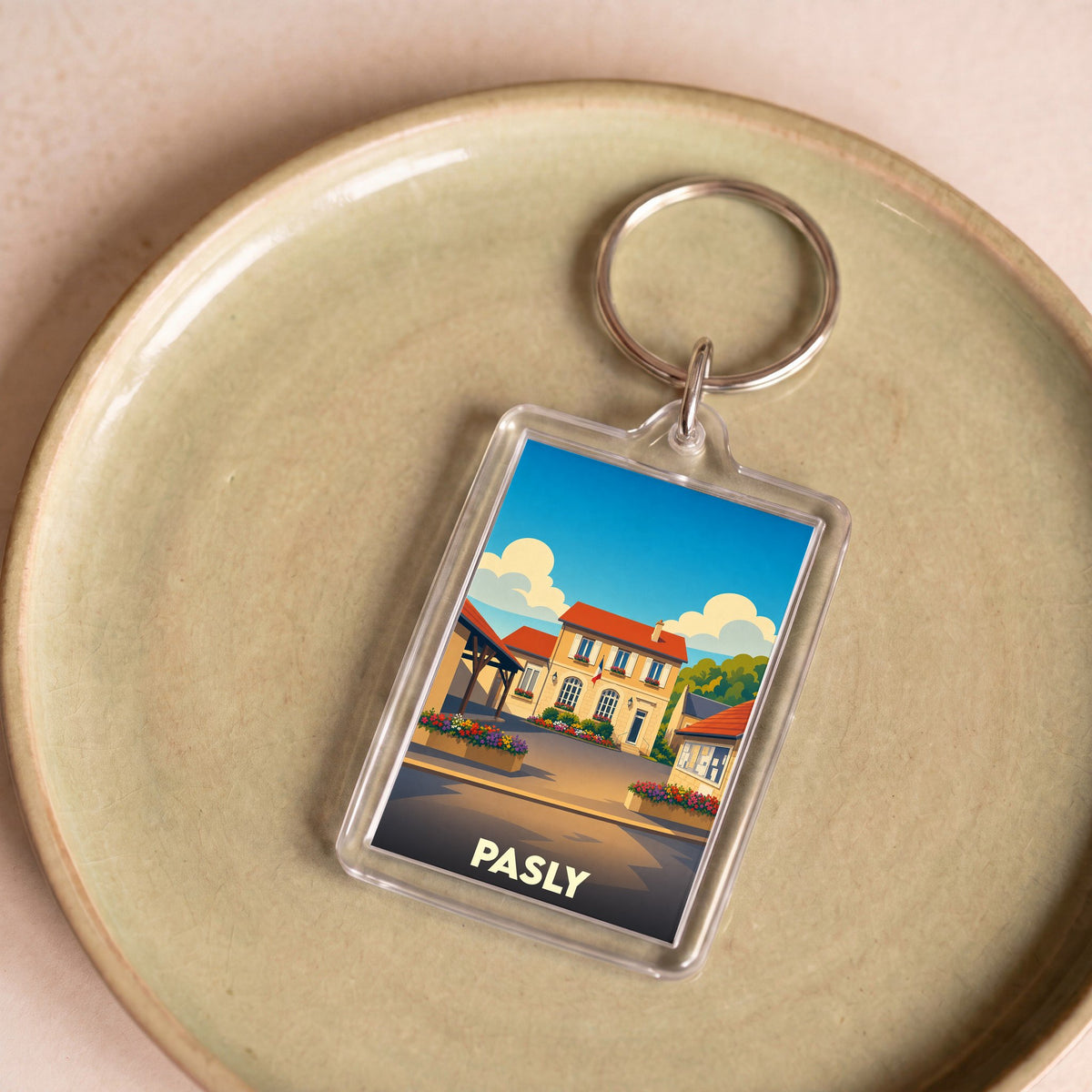 Porte-clés souvenir de la ville de Pasly avec une illustration stylisée.