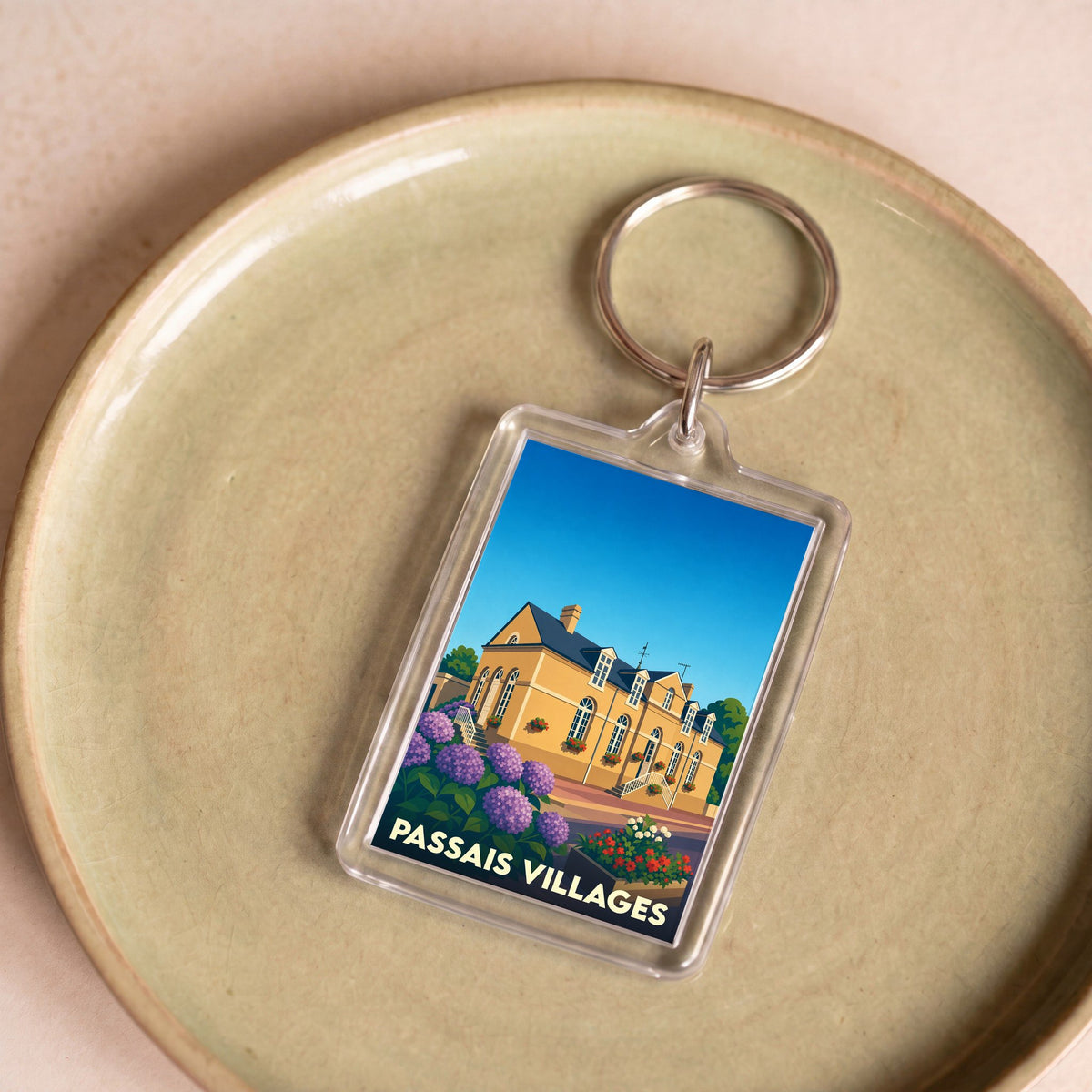 Porte-clés souvenir de la ville de Passais Villages avec une illustration stylisée.