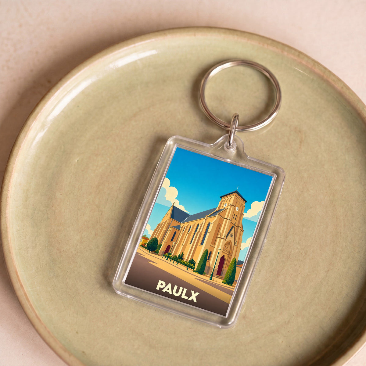 Porte-clés souvenir de la ville de Paulx avec une illustration stylisée de son église.