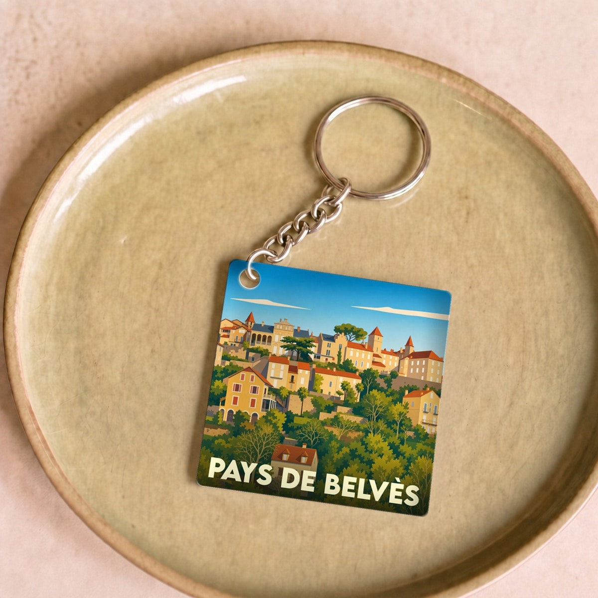 Porte-clés souvenir du Pays de Belvès avec une illustration stylisée du village médiéval.