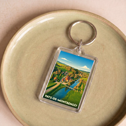 Porte-clés souvenir du Pays-de-Montbenoît avec une illustration stylisée d'un paysage rural.
