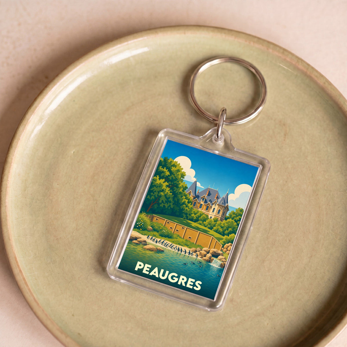 Porte-clés souvenir de la ville de Peaugres avec une illustration stylisée.