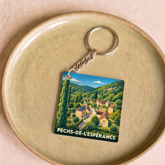 Porte-clés souvenir de Pechs-de-l'Espérance avec une illustration stylisée du village niché dans une vallée verdoyante.