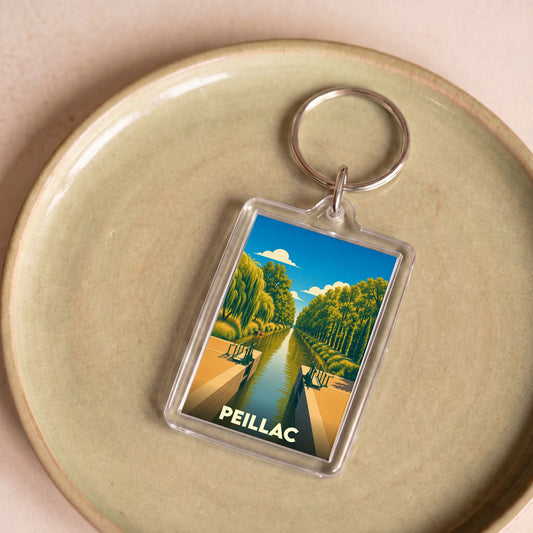 Porte-clés souvenir de la ville de Peillac avec une illustration stylisée d'un canal et d'une écluse.