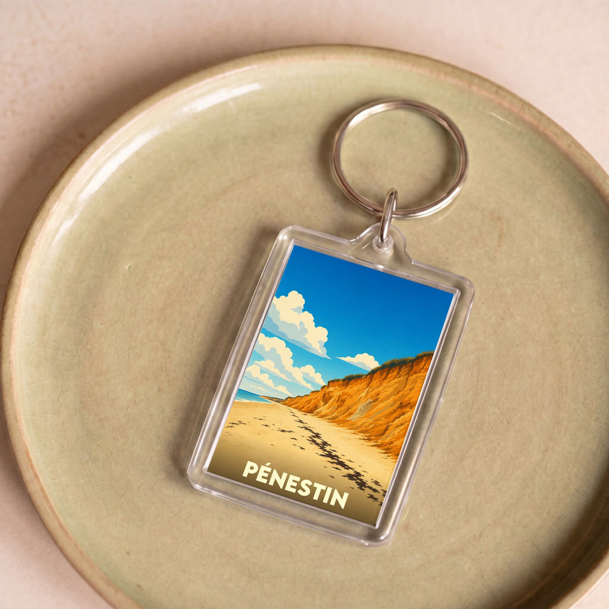 Porte-clés souvenir de la ville de Pénestin avec une illustration stylisée de ses falaises.