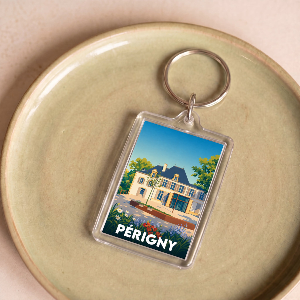 Porte-clés souvenir de la ville de Périgny avec une illustration stylisée d'une demeure historique.
