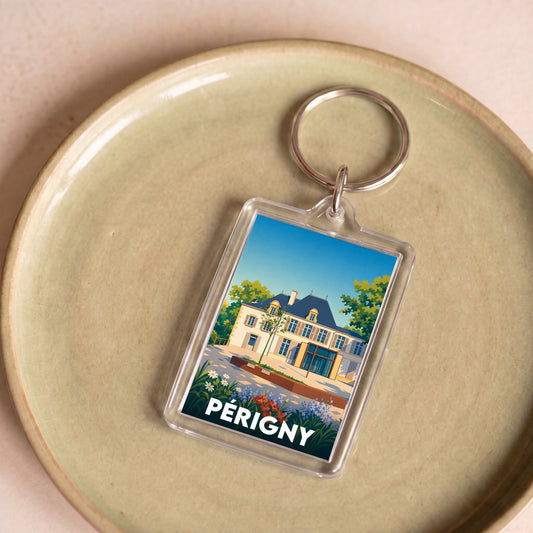 Porte-clés souvenir de la ville de Périgny avec une illustration stylisée d'une demeure historique.