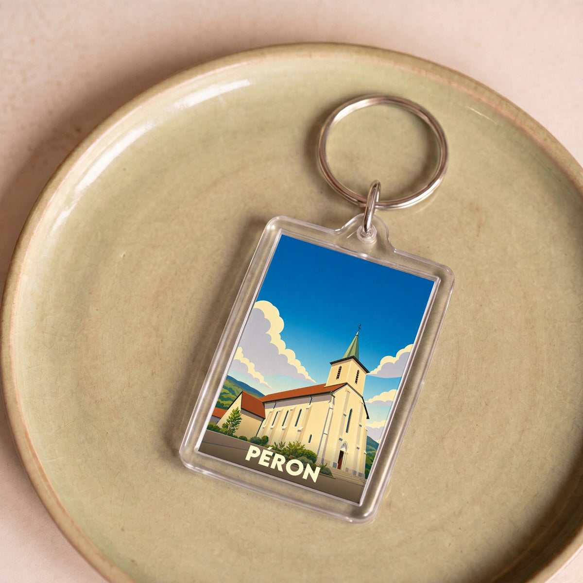 Porte-clés souvenir de la ville de Péron avec une illustration stylisée de son église.