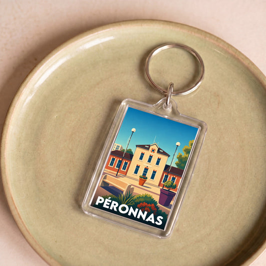 Porte-clés souvenir de la ville de Péronnas avec une illustration stylisée de son architecture.