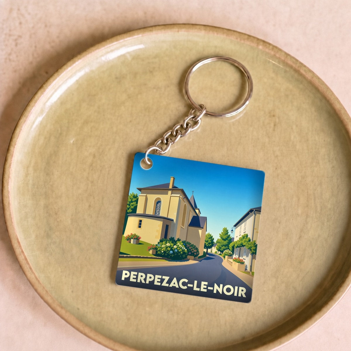Porte-clés souvenir de la ville de Perpezac-le-Noir avec une illustration stylisée.