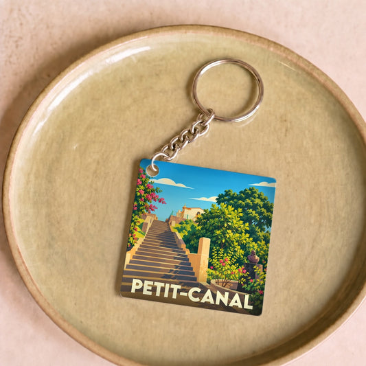 Porte-clés souvenir de la ville de Petit-Canal avec une illustration stylisée.