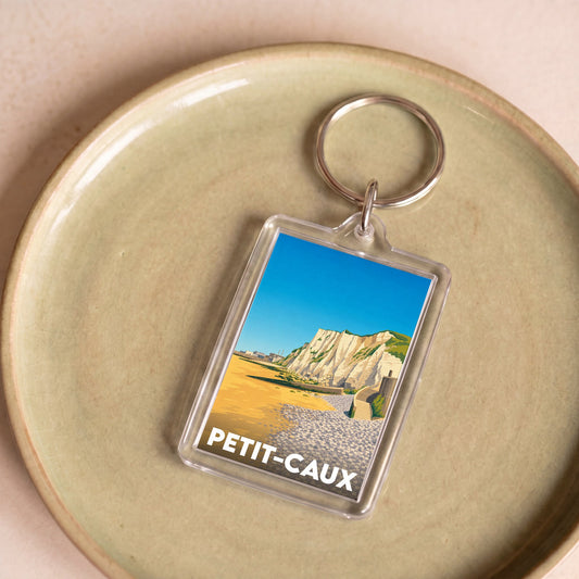 Porte-clés souvenir de la ville de Petit-Caux avec une illustration stylisée des falaises.