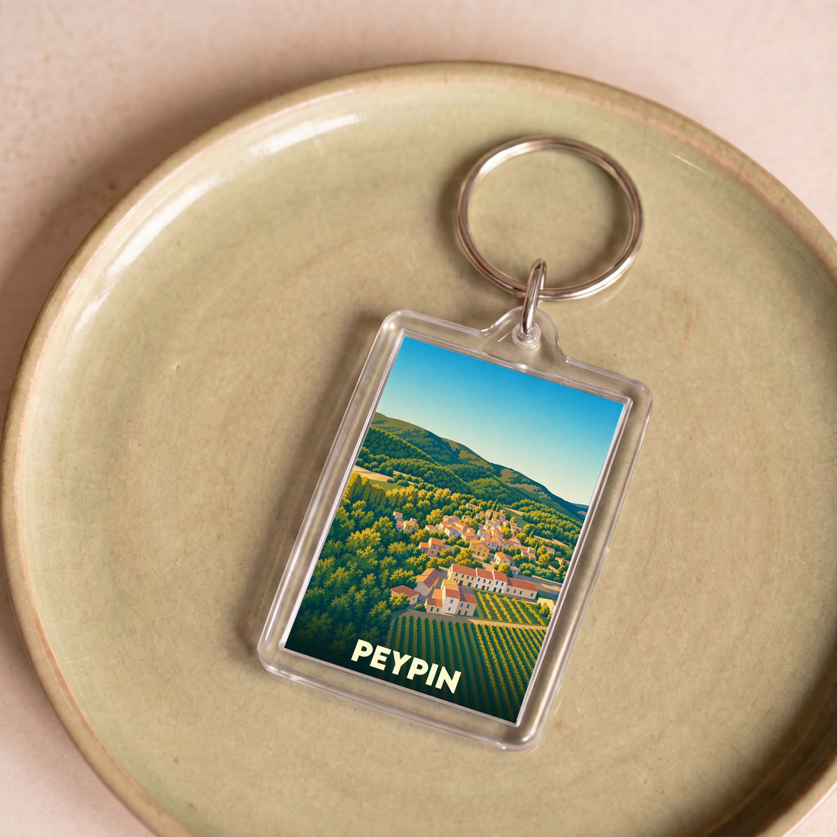 Porte-clés souvenir de la ville de Peypin avec une illustration stylisée d'un paysage provençal.