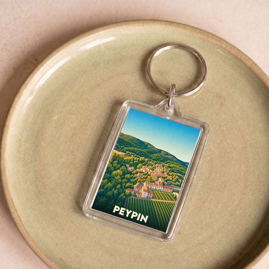 Porte-clés souvenir de la ville de Peypin avec une illustration stylisée d'un paysage provençal.
