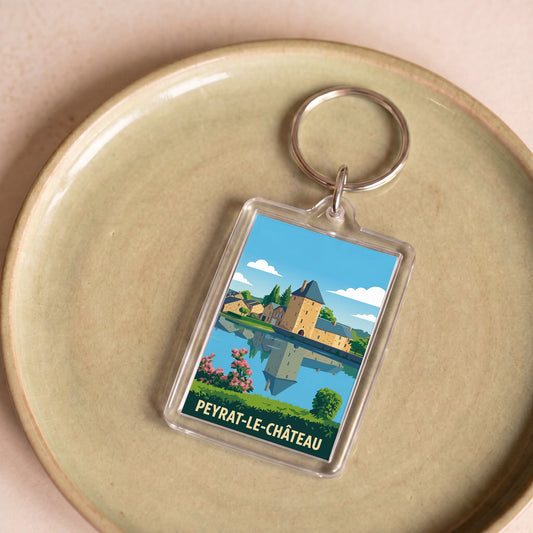 Porte-clés souvenir de la ville de Peyrat-le-Château avec une illustration stylisée.