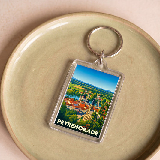 Porte-clés souvenir de la ville de Peyrehorade avec une illustration colorée et stylisée de son paysage.