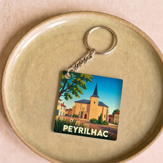 Porte-clés souvenir de la ville de Peyrilhac avec une illustration stylisée de son église.