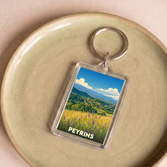 Porte-clés souvenir de la ville de Peyrins avec une illustration stylisée de paysages provençaux.