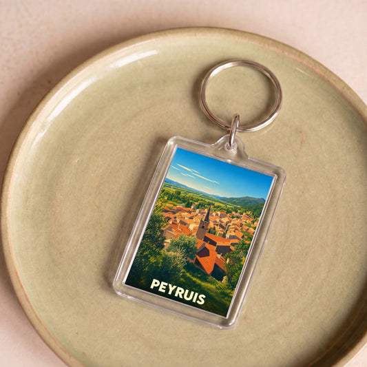 Porte-clés souvenir de la ville de Peyruis avec une illustration stylisée de ses toits provençaux.