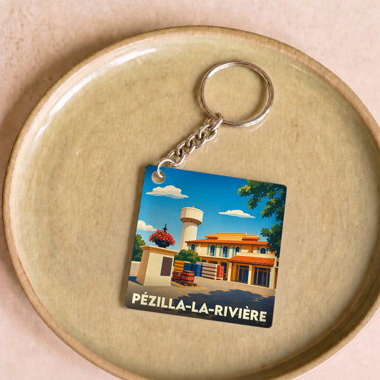 Porte-clés souvenir de la ville de Pézilla-la-Rivière avec une illustration stylisée.