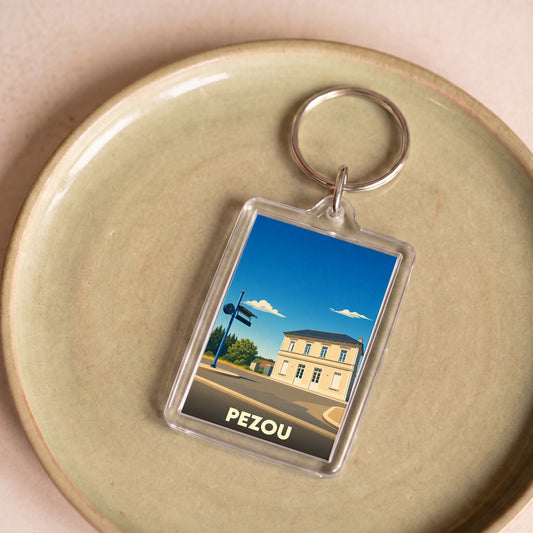 Porte-clés souvenir de la ville de Pezou avec une illustration stylisée.