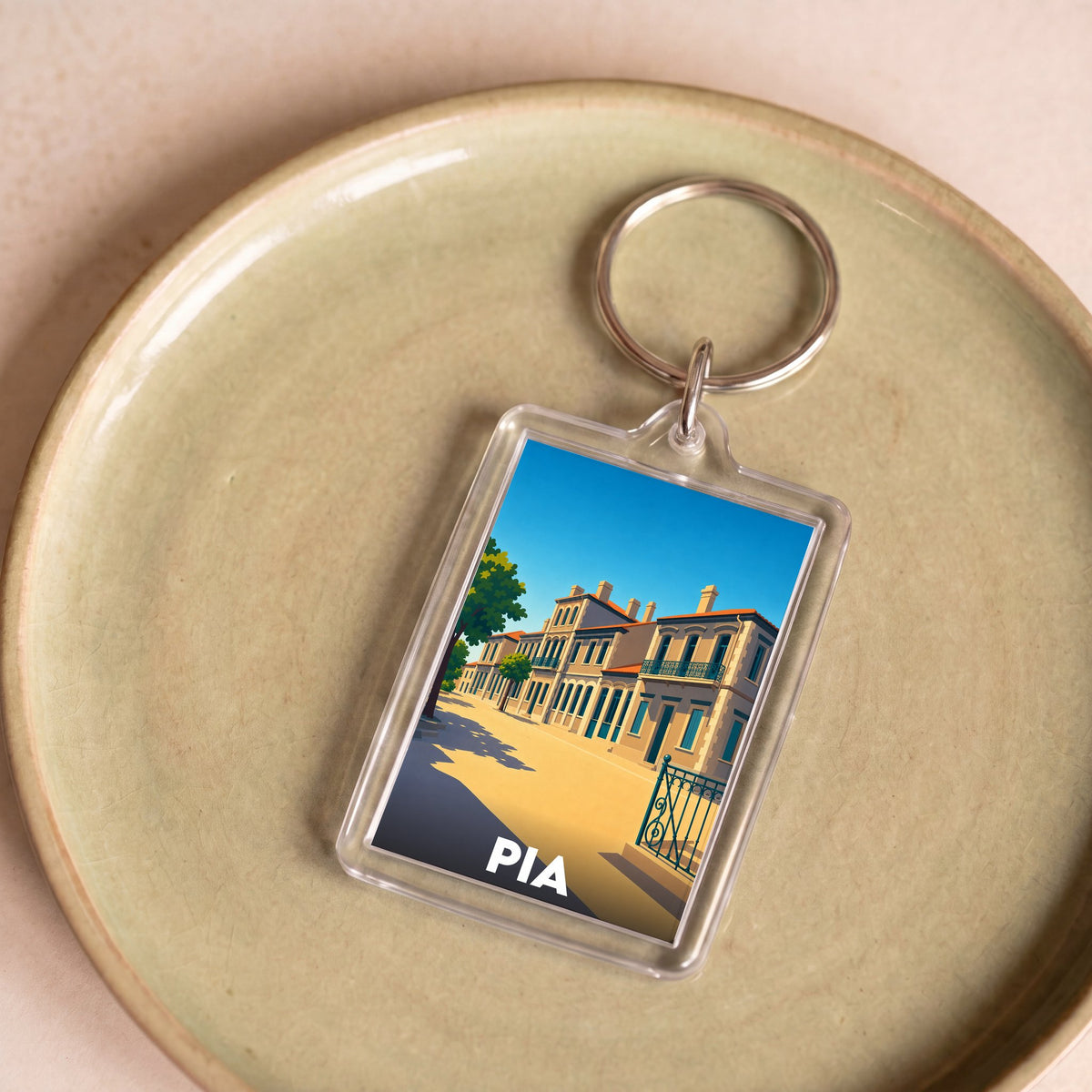 Porte-clés souvenir de la ville de Pia avec une illustration stylisée.