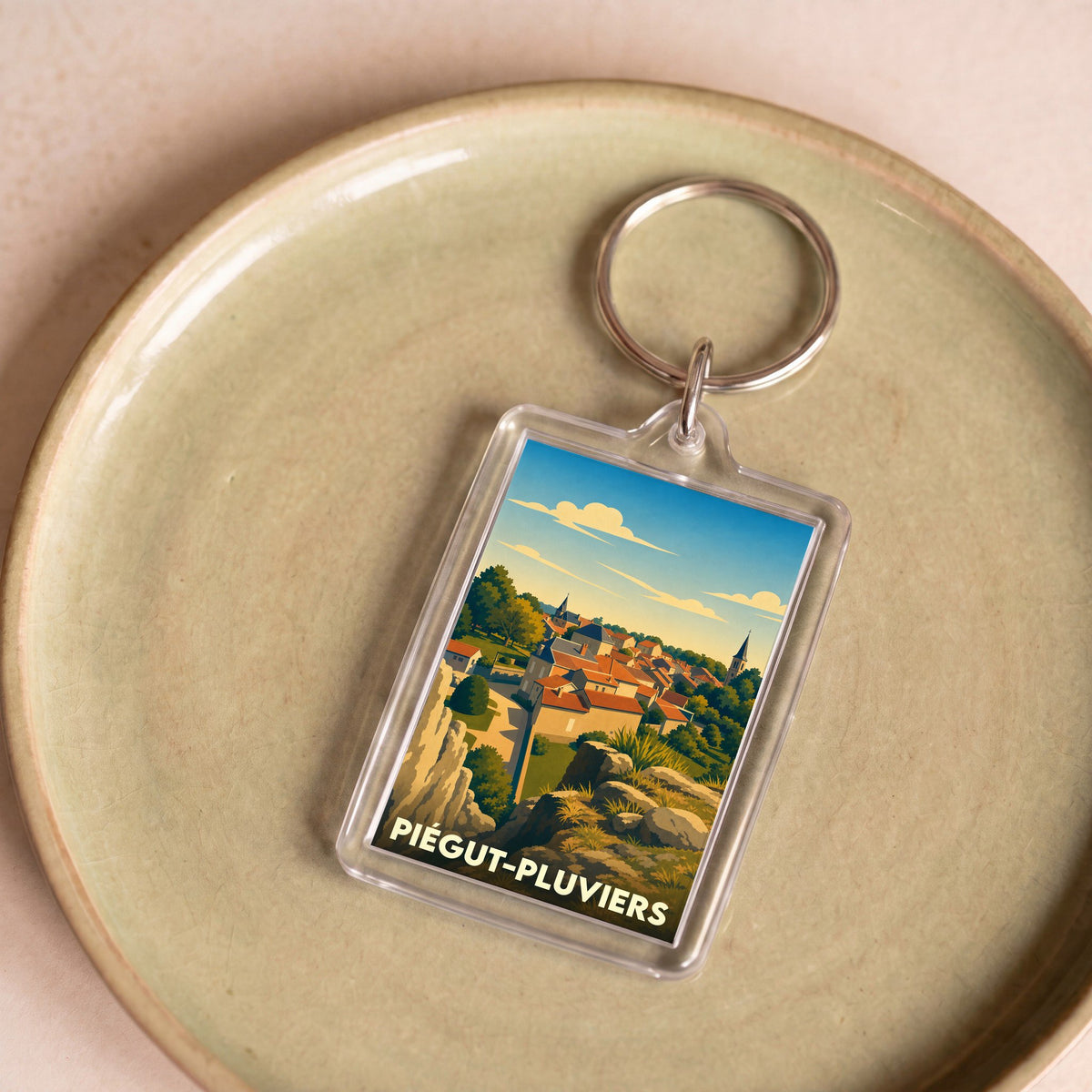 Porte-clés souvenir de la ville de Piégut-Pluviers avec une illustration stylisée.