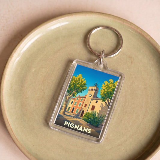 Porte-clés souvenir de la ville de Pignans avec une illustration stylisée.