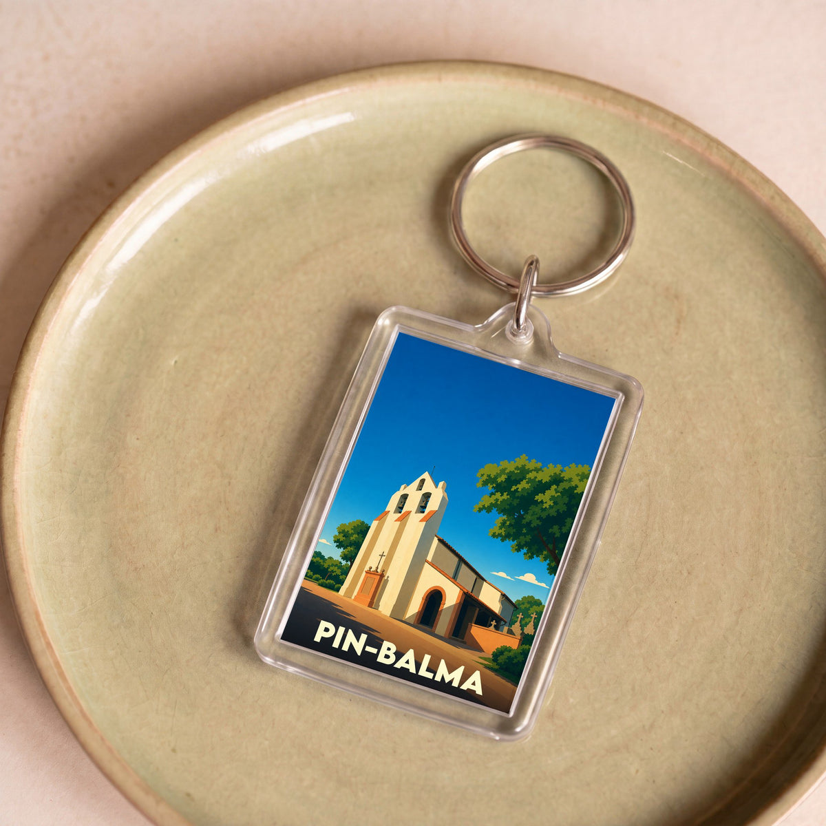 Porte-clés souvenir de la ville de Pin-Balma avec une illustration stylisée de son église.