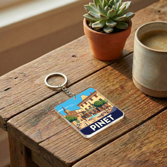 Porte-clés souvenir de la ville de Pinet avec une illustration stylisée.