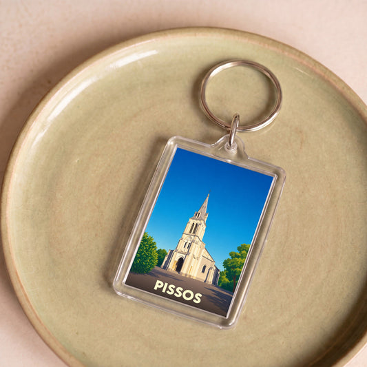 Porte-clés souvenir de la ville de Pissos avec une illustration stylisée de son église.