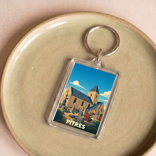 Porte-clés souvenir de la ville de Pîtres avec une illustration stylisée de son église et de son cimetière.