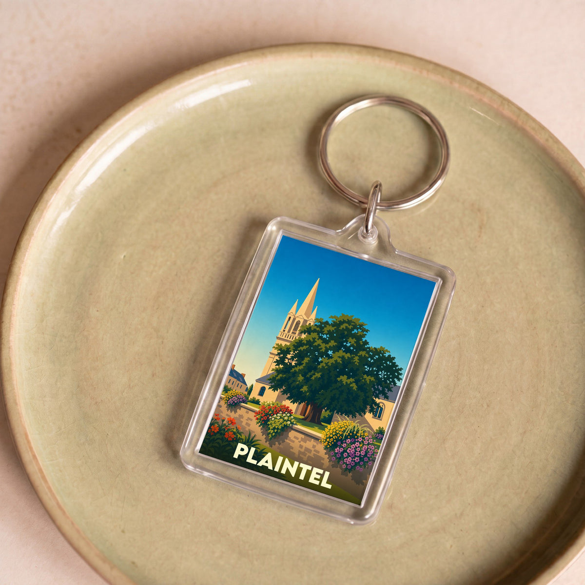 Porte-clés souvenir de la ville de Plaintel avec une illustration stylisée.