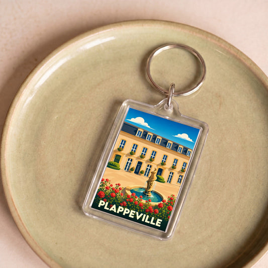 Porte-clés souvenir de la ville de Plappeville avec une illustration stylisée d'une demeure historique et sa fontaine.