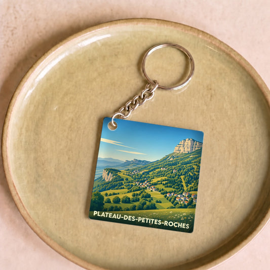 Porte-clés souvenir de la ville de Plateau-des-Petites-Roches avec une illustration de paysage montagneux.