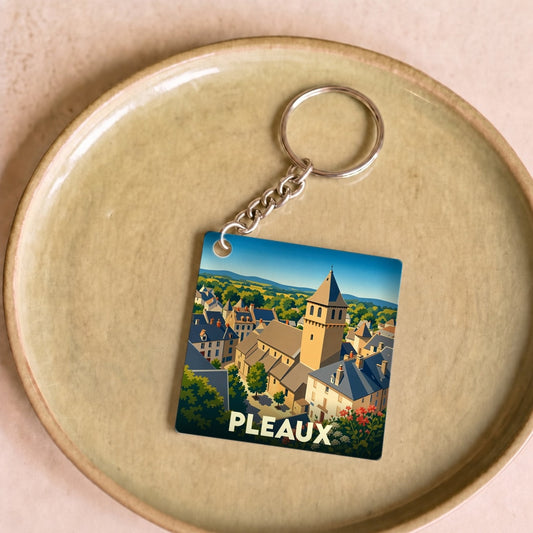 Porte-clés souvenir de la ville de Pleaux avec une illustration stylisée.